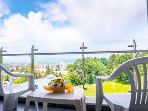 a balcony with two chairs and a table with flowers on it at Парк хотел Кюстендил in Kyustendil