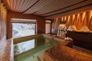 uma piscina no meio de uma sala com neve em Magic Megève Bois em Demi-Quartier