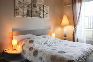 um quarto com uma cama, 2 candeeiros e uma janela em Bright well-appointed nest near Stade de France em Saint-Denis