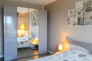 um quarto com uma cama e um armário espelhado com um espelho em Bright well-appointed nest near Stade de France em Saint-Denis