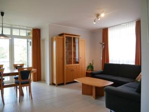 a living room with a couch and a table at Haus Roland- Whg 22 & 25 mit Schwimmbad und Sauna in Zinnowitz +47 photos