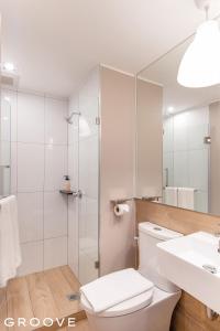 La salle de bains est pourvue de toilettes, d'un lavabo et d'une douche. dans l'établissement GROOVE AT SIAM, à Pom Prap