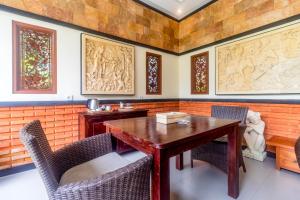 uma sala de jantar com uma mesa de madeira e cadeiras em Asli Bali Villas em Bangli