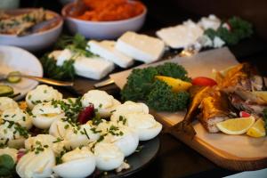 a table topped with plates of food with eggs and vegetables at Hotel Artus - Old Town in Gdańsk