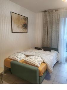 a bedroom with a bed and a green couch at Charming T2 (44M2) bright with Terrace in Villeurbanne