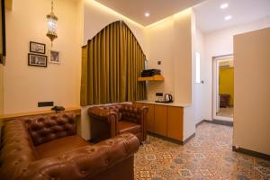 a living room with a leather couch and a table at Ra Residence - Agarwal Group of Hotels in Pune