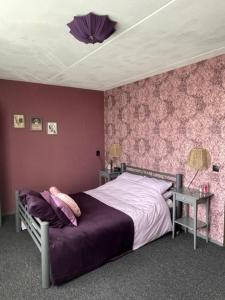 een slaapkamer met een bed en een paarse muur bij Bed and breakfast devijfbees in Barendrecht
