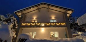 a house with christmas lights on the balcony at night at Residence Alba Montis in Bad Kleinkirchheim