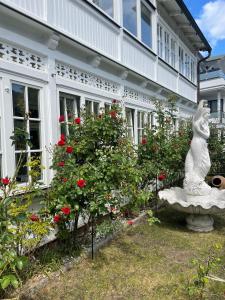 a statue in front of a building with roses at Villa Waldrose in Binz
