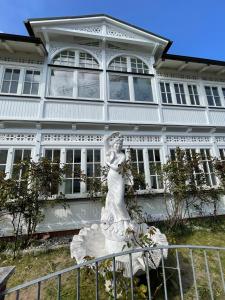a statue of a woman in front of a white building at Villa Waldrose in Binz