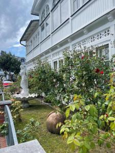 a garden in front of a building with a statue at Villa Waldrose in Binz