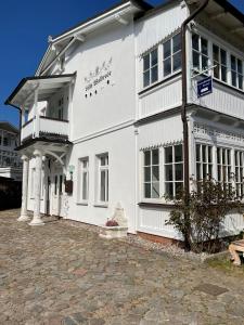 a white building with a balcony on the side of it at Villa Waldrose in Binz
