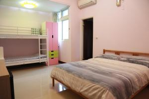 花蓮市的住宿－朋友的家，一间卧室配有两张双层床和粉红色的橱柜