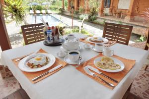 a table with plates of breakfast food on it at Bon Nyuh Bungalows in Gianyar