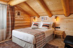 ein Schlafzimmer mit einem Bett in einem Blockhaus in der Unterkunft Chalet Rozmarin Predeal in Predeal
