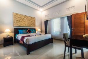 a bedroom with a bed and a desk and a desk at Asli Bali Villas in Bangli