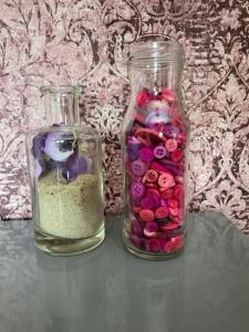 dos jarrones de cristal llenos de cuentas en una mesa en Bed and breakfast devijfbees en Barendrecht