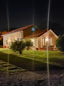 una casa por la noche con las luces encendidas en Casas Cuncheiro, en Canduas
