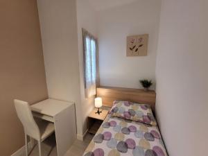 niewielka sypialnia z łóżkiem i biurkiem w obiekcie Bed&BCN Forum w mieście Sant Adria de Besos