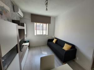 Bed&BCN Forum في سان أدريان دي بيزوس: غرفة معيشة مع أريكة سوداء ونافذة