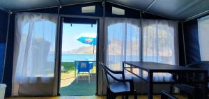 um quarto com uma mesa e vista para o oceano em Camping Pilzone em Iseo