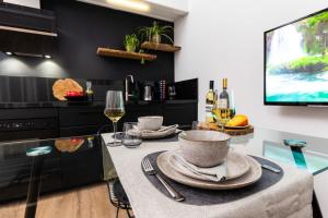 a kitchen with a table with wine glasses and a tv at 2 Double floor Delft City Centre new family apartment in Delft