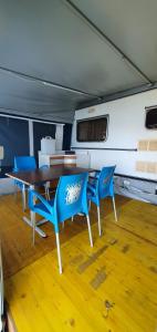 a dining room with a table and blue chairs at Camping Pilzone in Iseo