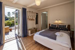 1 dormitorio con 1 cama grande y puerta corredera de cristal en Norsminde Kro Anneks, en Odder