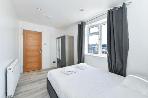 a bedroom with a white bed and a window at Windmill Villa in Warsop