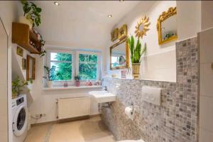 ein Badezimmer mit Waschbecken und Waschmaschine in der Unterkunft Dachgeschosswohnung Scharbeutz mit Garten in Scharbeutz