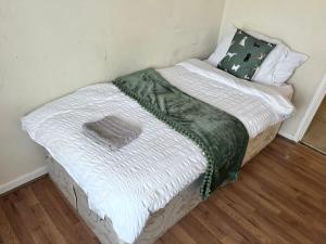 a small bed in a corner of a room at Beautiful 3-Bed House in High Wycombe in High Wycombe