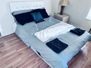 a large bed with blue sheets and pillows on it at Beautiful 3-Bed House in High Wycombe in High Wycombe