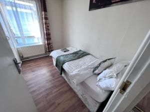 a small bedroom with a bed and a window at Beautiful 3-Bed House in High Wycombe in High Wycombe