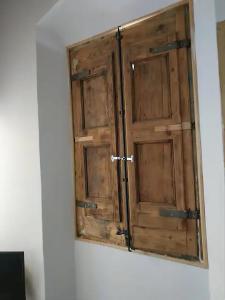 eine Holztür an einer Wand in einem Zimmer in der Unterkunft Apartamento de diseño cerca de tren, playa y BCN in Masnou