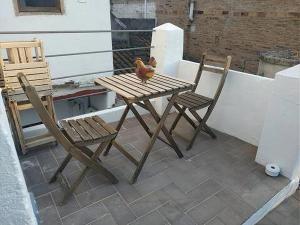 einen Holztisch und zwei Stühle auf einer Terrasse in der Unterkunft Apartamento de diseño cerca de tren, playa y BCN in Masnou