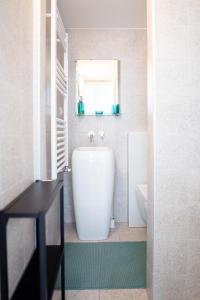 uma casa de banho com uma banheira, um WC e uma janela. em Loft Giulietta em Milão