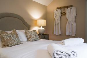 a bedroom with a white bed with towels on it at Maplewood Cottage, Wynyard Hall 