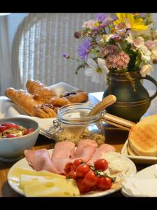 a table with plates of food and a vase of flowers at Beckside Cracoe in Skipton