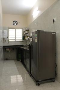 a kitchen with a stainless steel refrigerator and a counter at Radharani Apartment in Kolkata