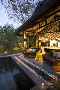 an outdoor patio with couches and a swimming pool at Tolani Southgate Villa Chiang Mai in Chiang Mai
