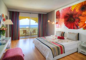 a bedroom with a bed with a flower painting on the wall at One Resort Jockey Monastir in Monastir