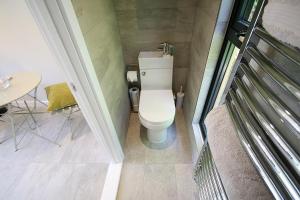 a small bathroom with a toilet and a table at Sunridge EcoPod with Private Hot Tub in Plymouth