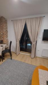 una sala de estar con una ventana con cortinas en Sneska Jahorina, en Jahorina
