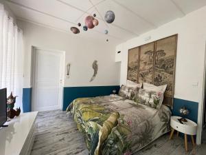a bedroom with a bed and a painting on the wall at La Maison Blanche de Lanton in Lanton +29 photos