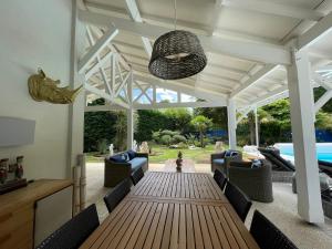a patio with a wooden table and chairs at La Maison Blanche de Lanton in Lanton
