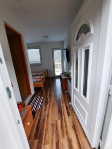 um corredor com piso de madeira e uma porta em Apartmani Biser Drine em Foca