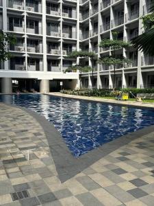 a swimming pool in front of a large building at Shore 2 Apartment with Balcony in Manila