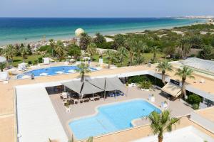 an aerial view of a resort with a pool and the beach at One Resort Jockey Monastir in Monastir