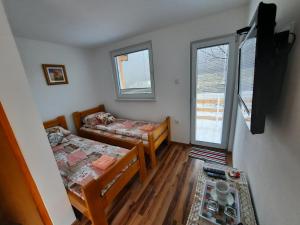 Kleines Zimmer mit 2 Betten und einem Flachbild-TV. in der Unterkunft Apartmani Biser Drine in Foča