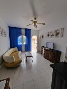 ein Wohnzimmer mit einem Sofa und einem Deckenventilator in der Unterkunft Casa Alegría in Playas de Orihuela